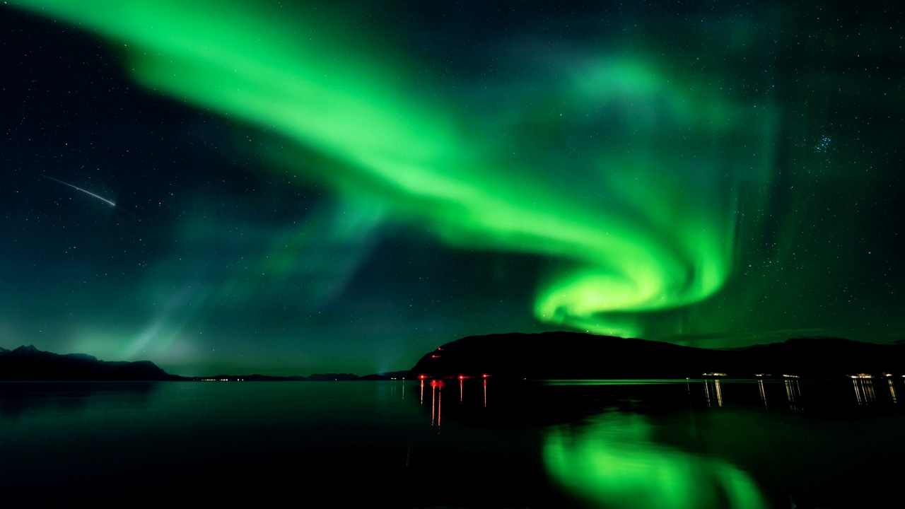 壮丽的绿色极光在山上星空背景下与镜子反射在湖面上。4 k视频下载