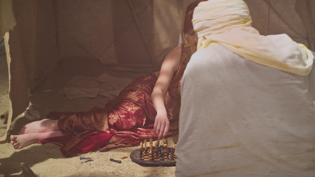 沙漠帐篷里象征性的象棋游戏。女人和男人，黑暗和光明视频素材