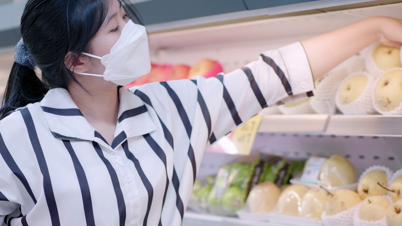 亚洲少女戴着口罩走在超市买杂货视频下载