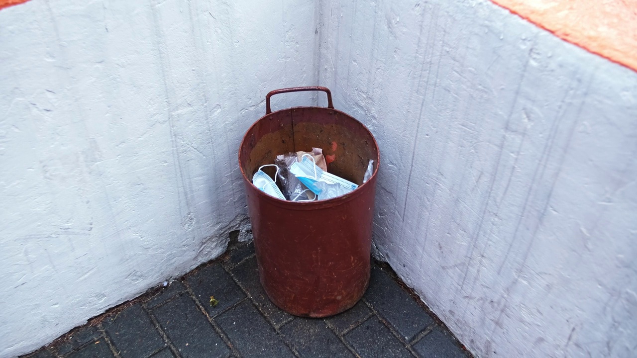 一次性卫生外科口罩倾倒在户外金属垃圾垃圾桶垃圾桶视频素材