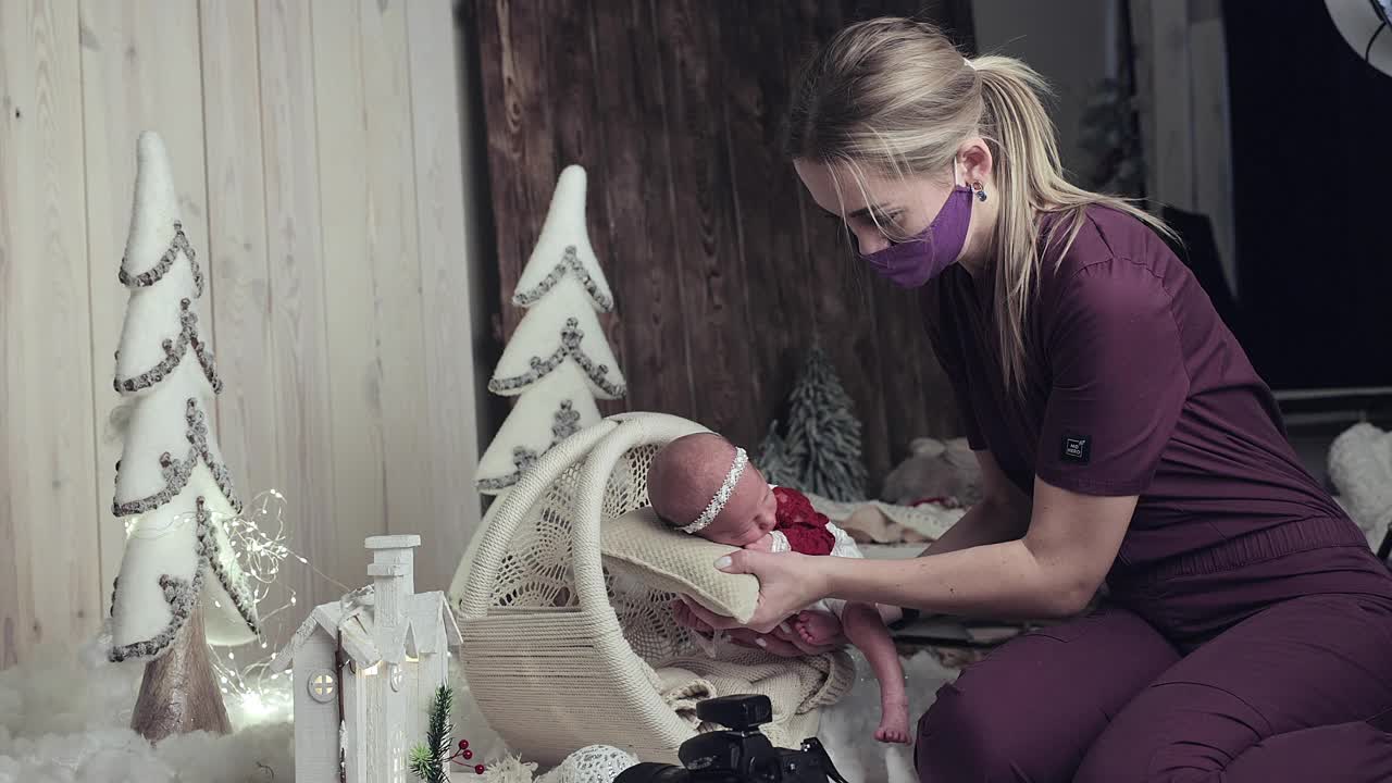 摄影师把刚出生的婴儿摆好拍照的姿势。视频素材