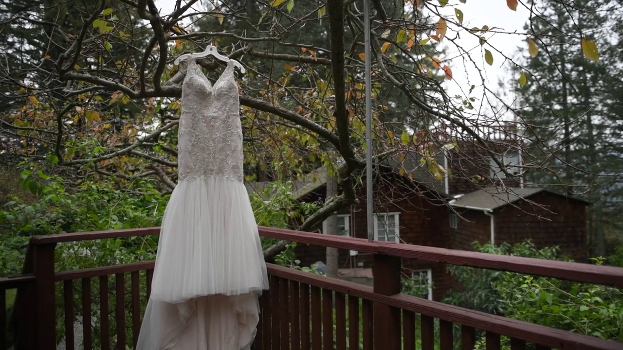 婚礼礼服挂在房子附近的树的背景下视频素材