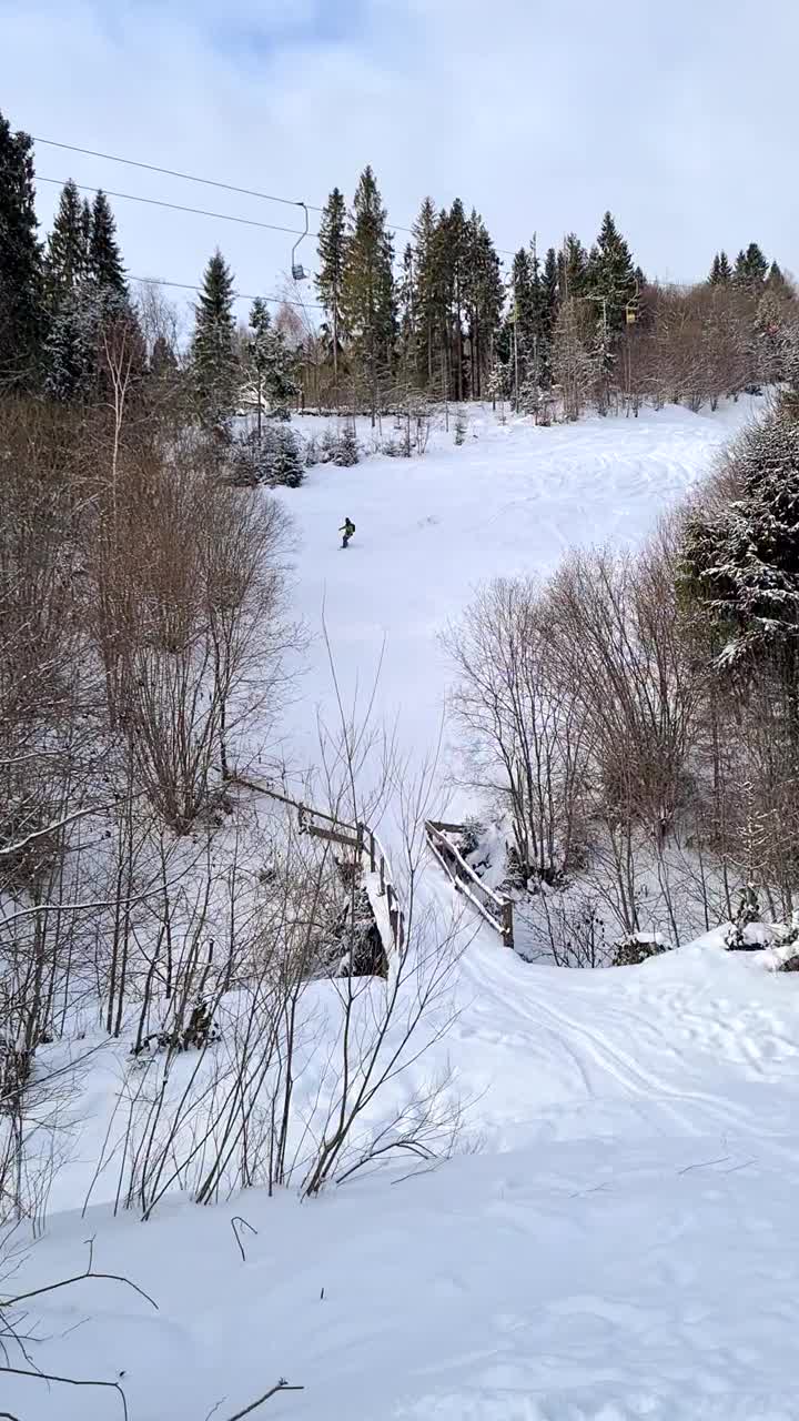 男子在经过大桥的斜坡上滑雪视频素材