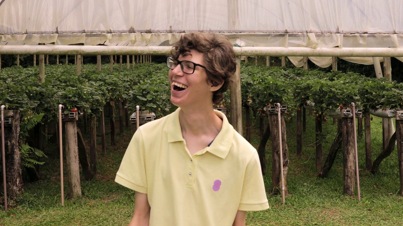 患有脑瘫的男孩在有机草莓农场温室前大笑视频下载