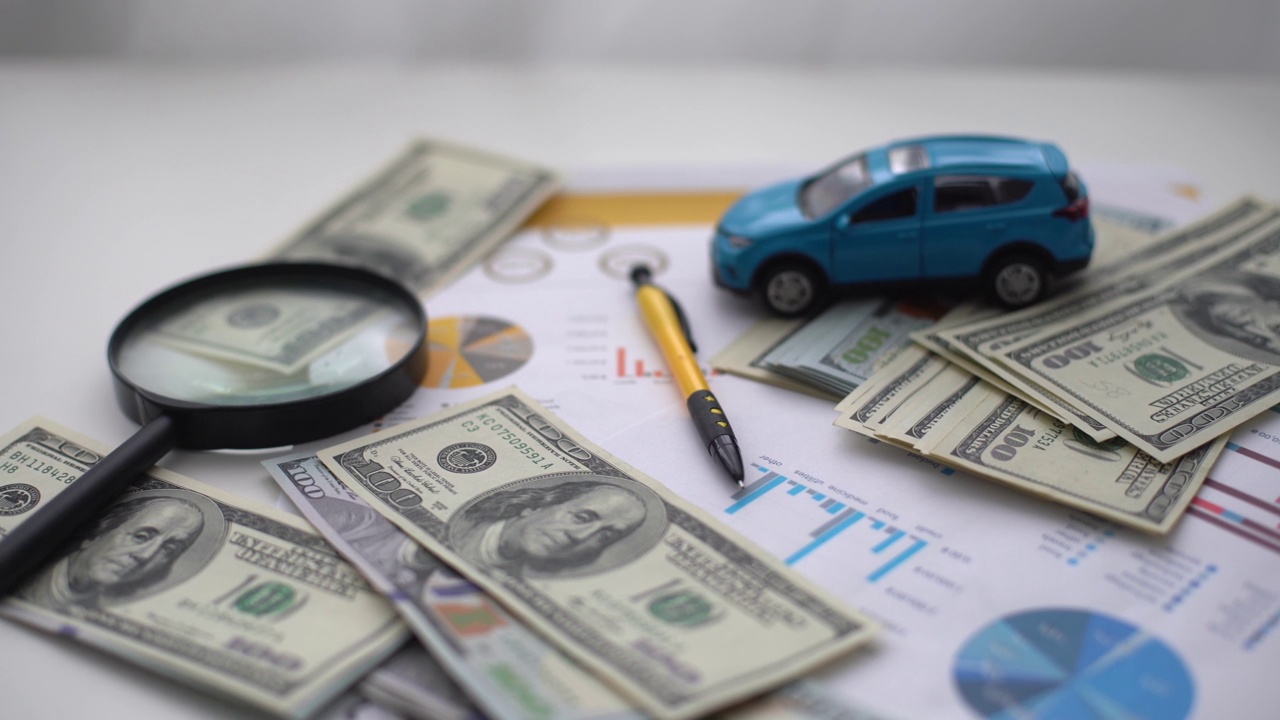汽车保险的概念。汽车模型驾驶在金钱和保险文件的背景视频下载