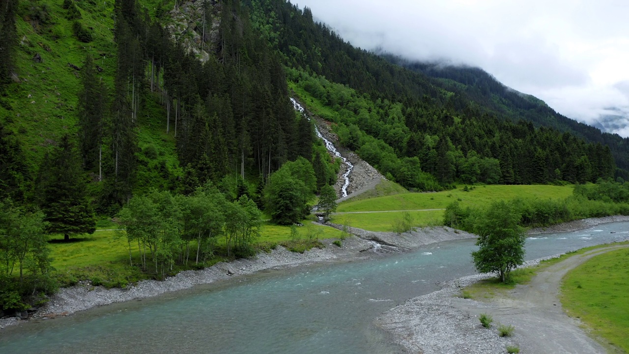 在松树林中向山河和瀑布飞行。奥地利蒂罗尔州视频素材