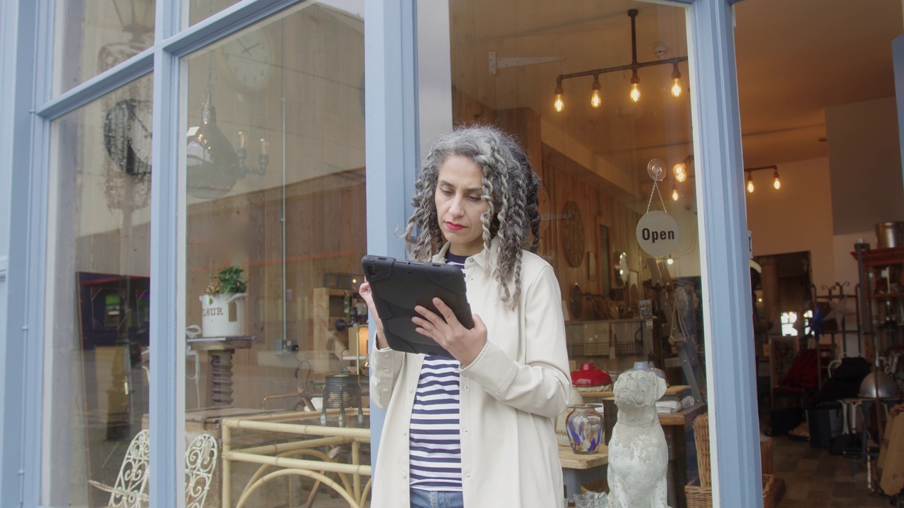女企业家在商店外使用数码平板电脑视频素材