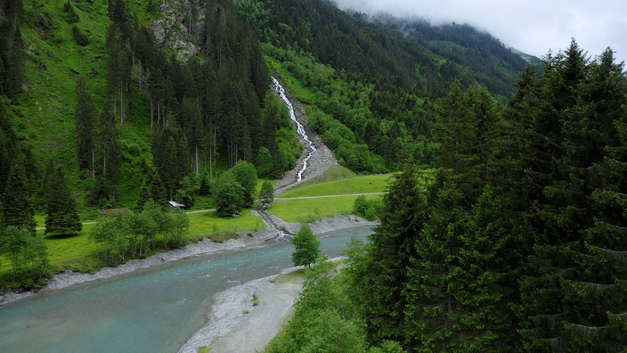 空中沿着山河飞行，背景是蓝色的水和美丽的瀑布。奥地利蒂罗尔州视频素材
