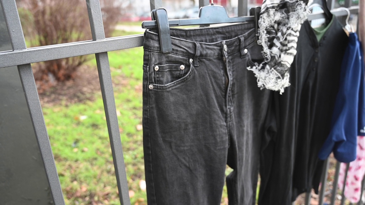 一个人把挂在免费栅栏上的内裤/裤子拿走(捐赠)。德国。视频下载