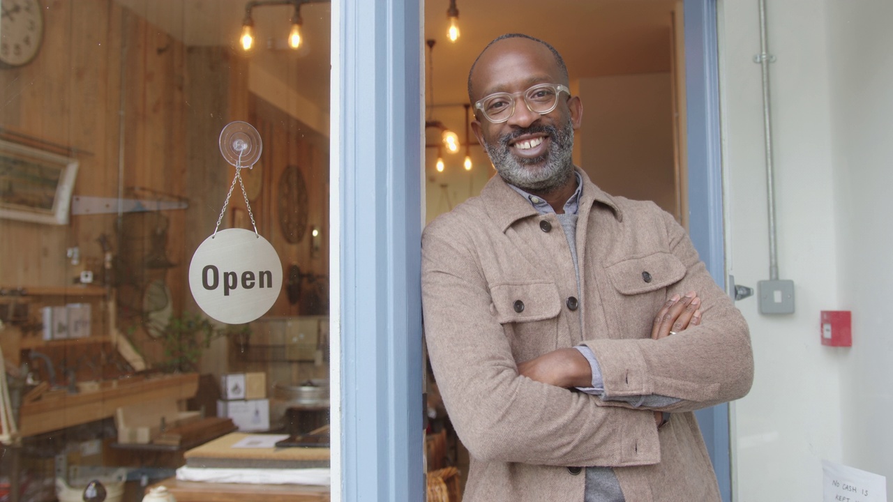 黑人男性小商店老板看着镜头微笑的肖像视频素材