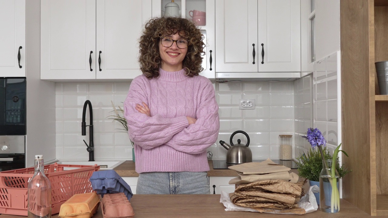 骄傲的年轻女性和厨房柜台上的回收员工的肖像视频下载