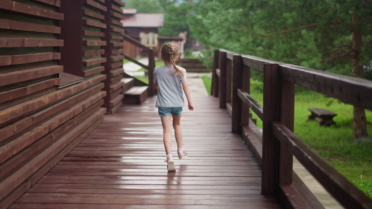 穿着短裤的小女孩在阳台上自由地奔跑视频下载