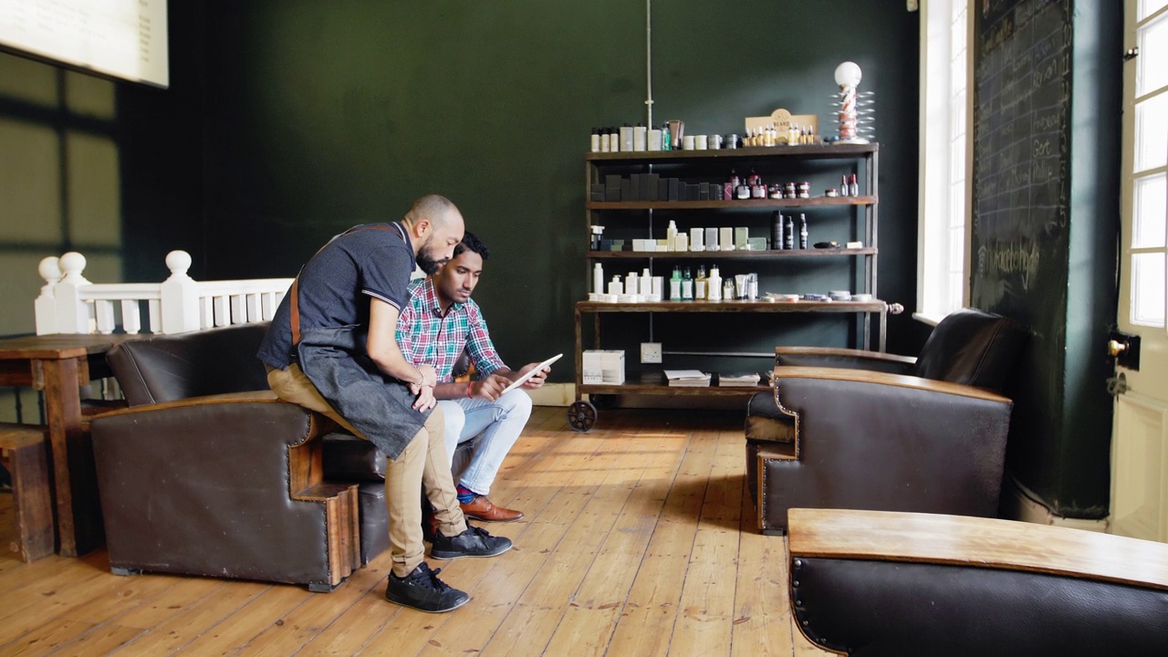 理发师和男人在理发店使用数码平板电脑视频下载
