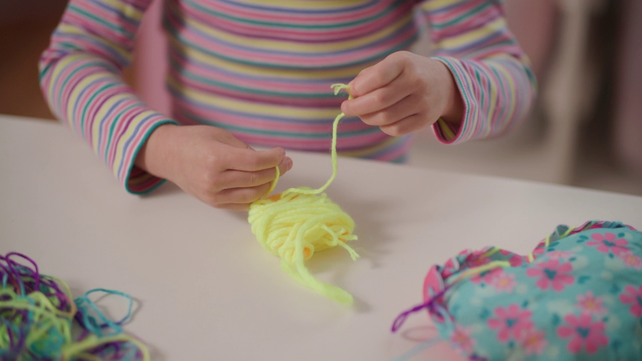 年轻女孩在家里用塑料针和纱线缝制衬垫工艺视频下载