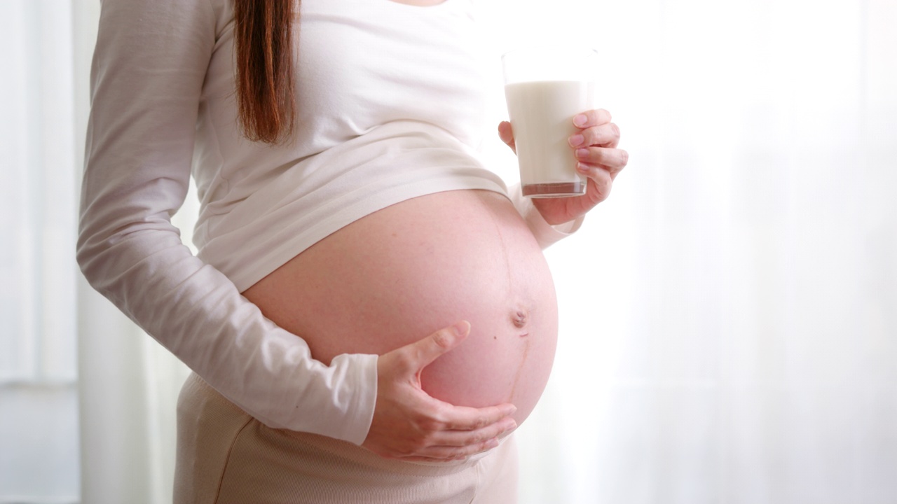 快乐的孕妇喝一杯新鲜的牛奶。健康的钙，茶点视频下载