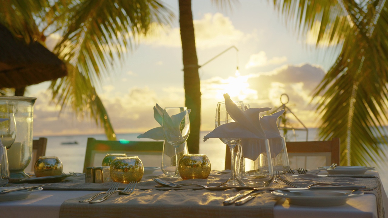浪漫的晚餐会为两人在夕阳下的海滩上美丽的云彩背景视频下载