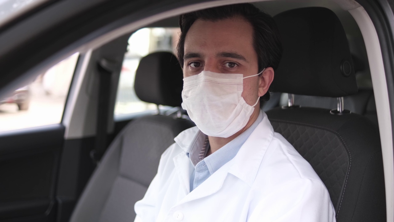 一个拉丁医生的肖像在他的车上，戴着防护面罩视频下载