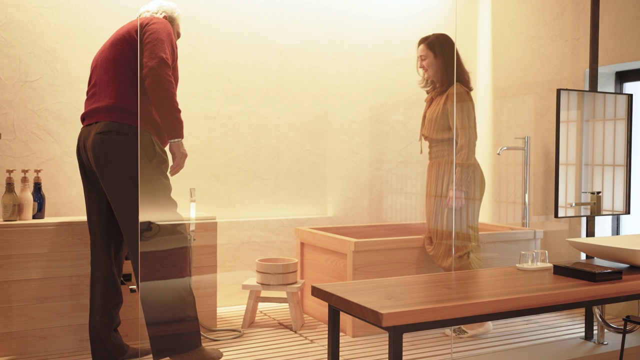 一对西班牙夫妇喜欢在京都的一个联排别墅的私人酒店里看一个现代的日本浴室。视频素材