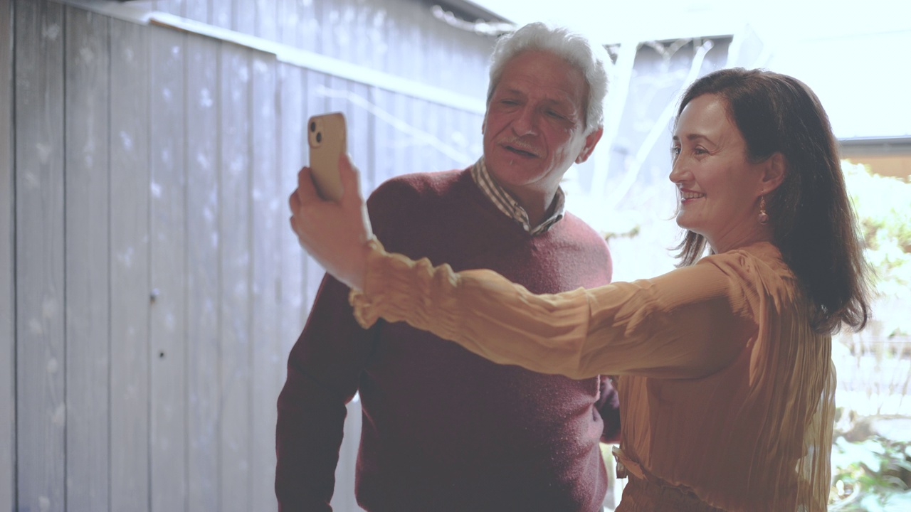 一对西班牙夫妇用智能手机自拍，背景是花园。视频下载