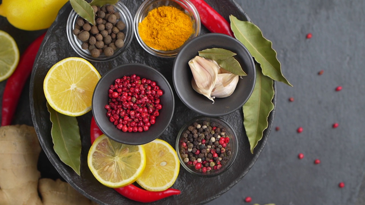 在碗中烹饪用的各种香草和香料的彩色背景。俯视图视频下载
