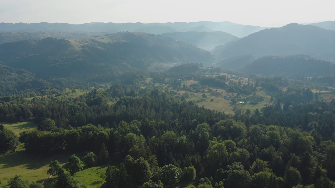 在一个夏天的早晨，鸟瞰图中，浓雾笼罩着山谷周围的群山。视频下载