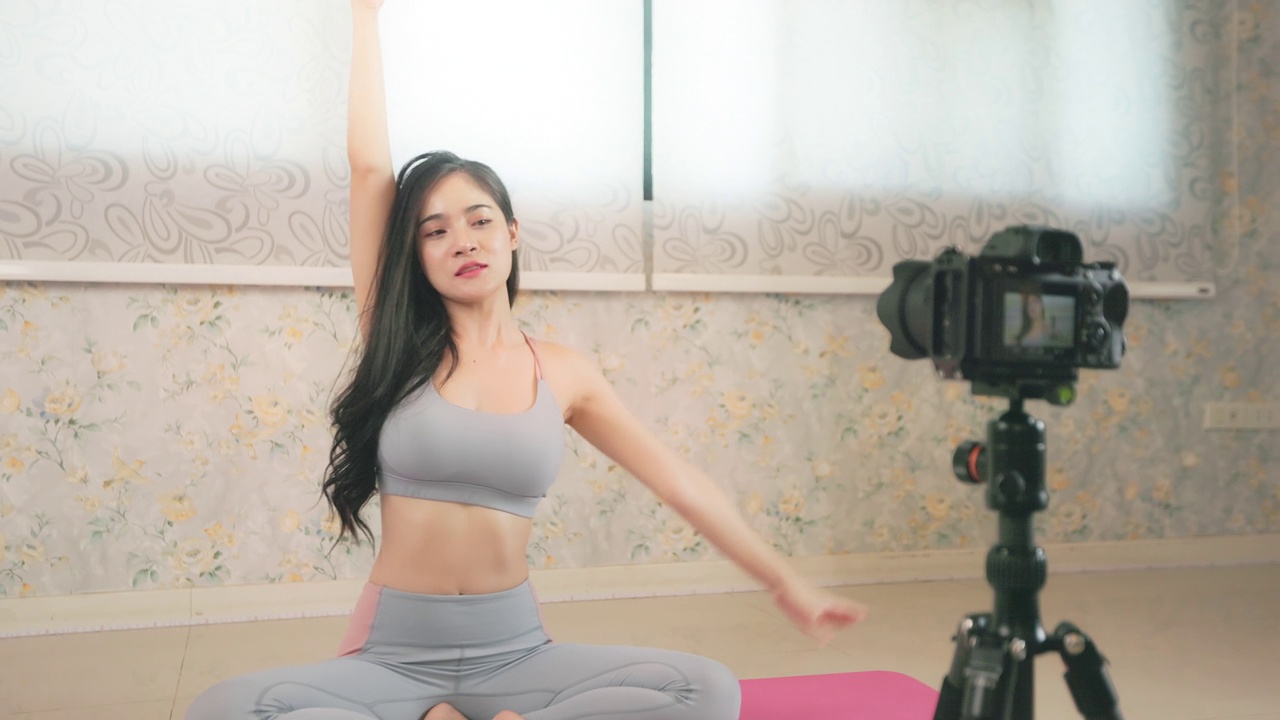 年轻的亚洲妇女教瑜伽在线或现场直播在家里为健康或健康的生活方式概念。视频下载