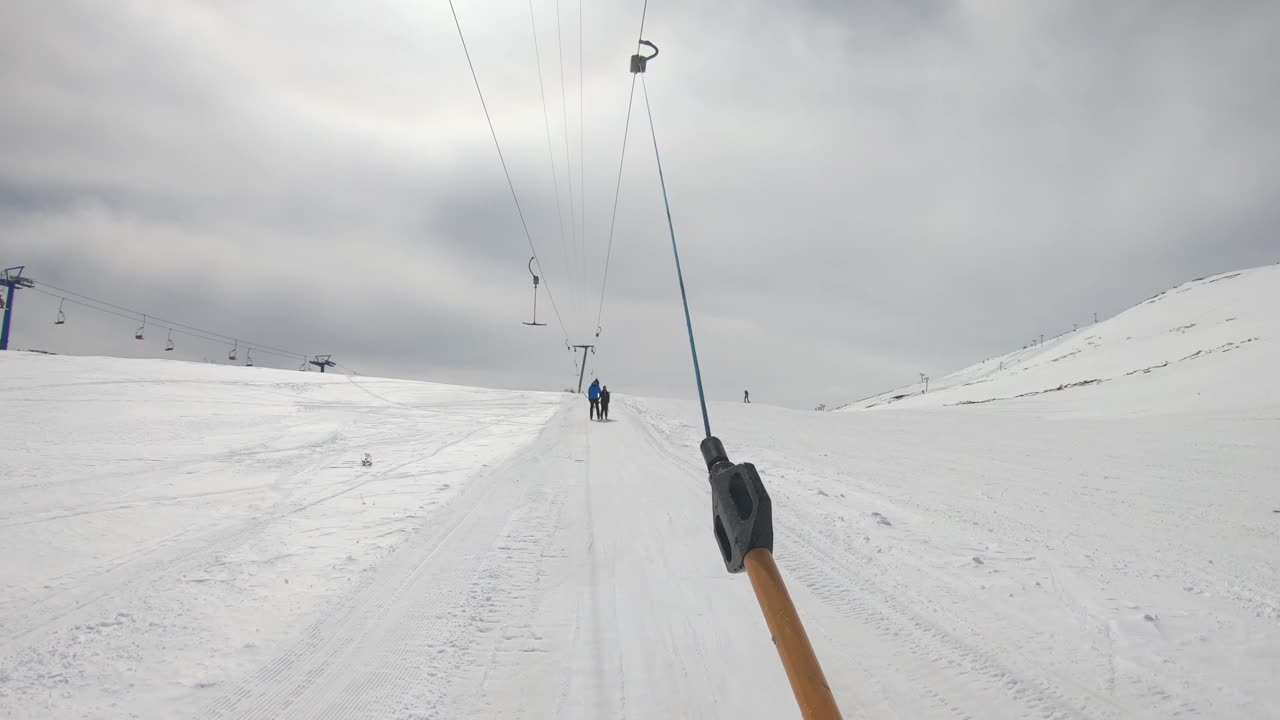 滑雪者手持索道t形杆，在滑雪场、坡道、坡道上升视频下载