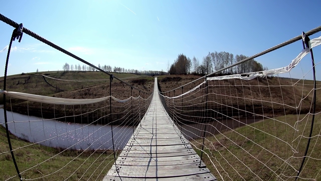 镜头沿着国家公园里横跨河流的索桥移动视频下载