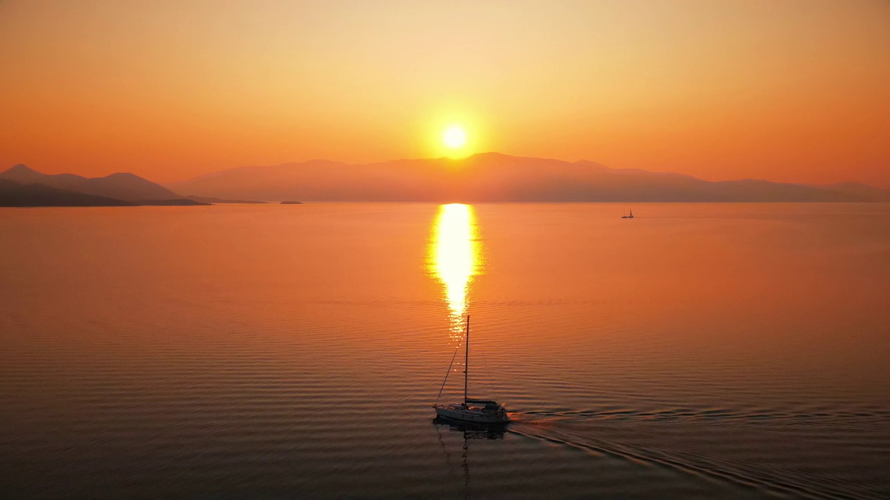希腊爱奥尼亚海岸的日落。明亮的阳光，远处的陆地，漂浮的小船，水中的倒影视频素材