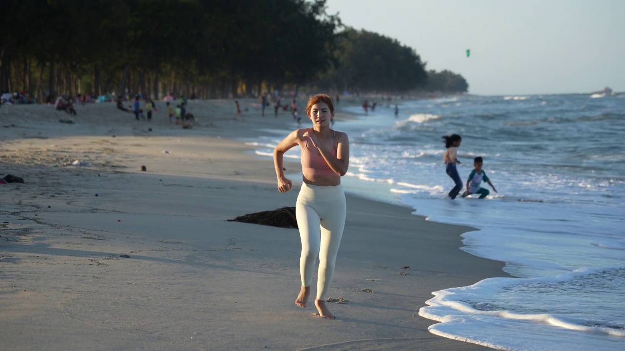 健康的生活方式年轻女子在海滩上跑步视频购买