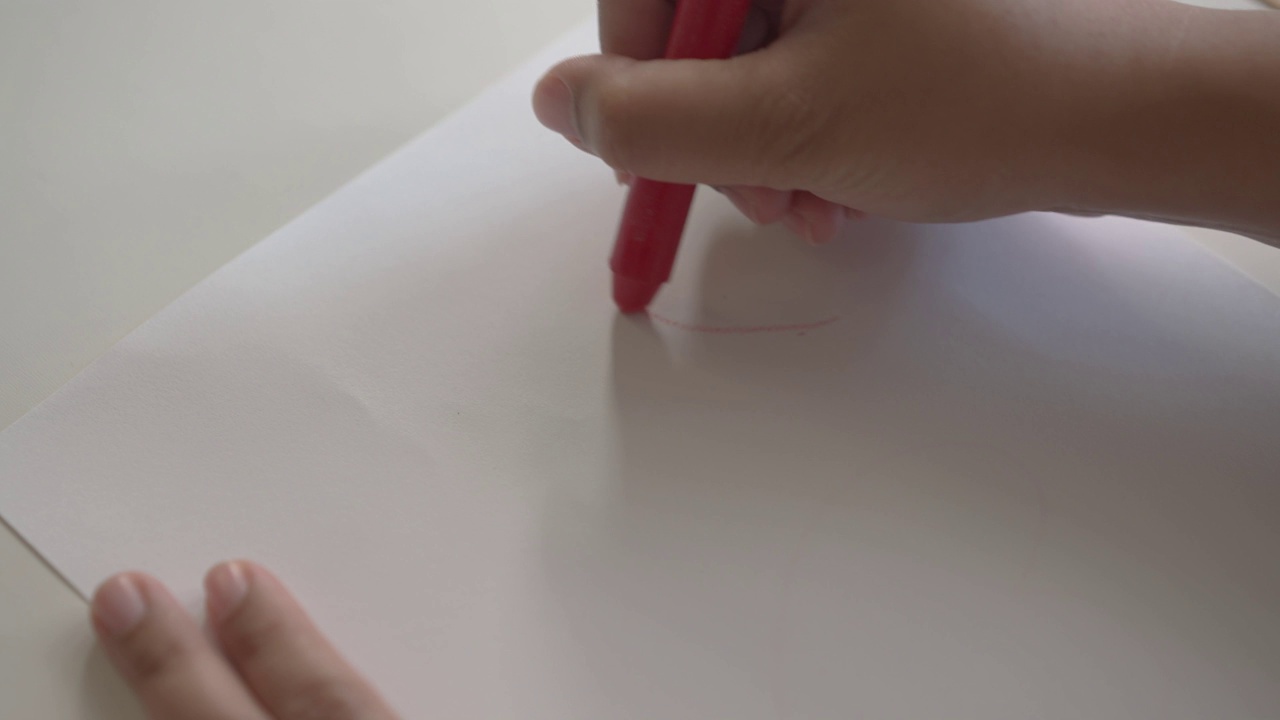 女人用蜡笔在白纸上画了一个红心的形状视频下载