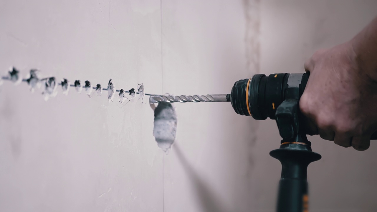 施工人员用打孔机在混凝土墙上打洞安装出水口视频素材