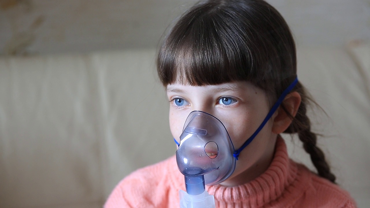 小孩用喷雾器吸气。呼吸系统疾病的治疗视频下载