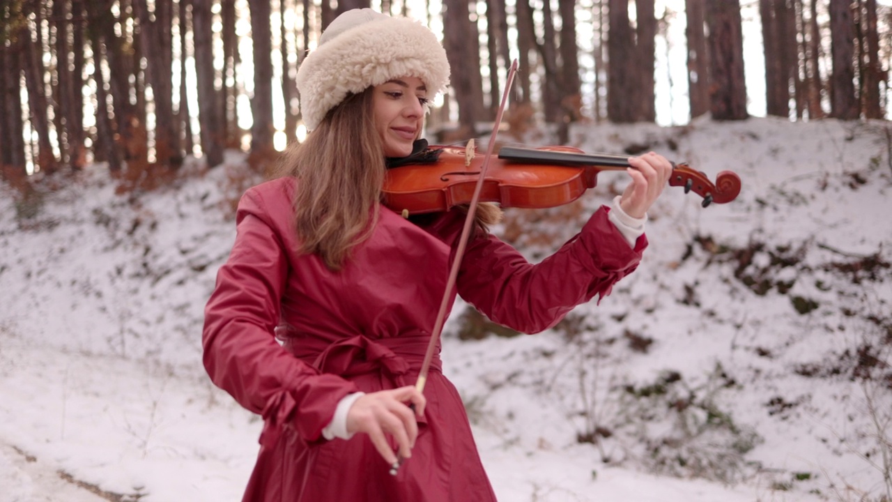 在雪地上拉小提琴的女人视频素材