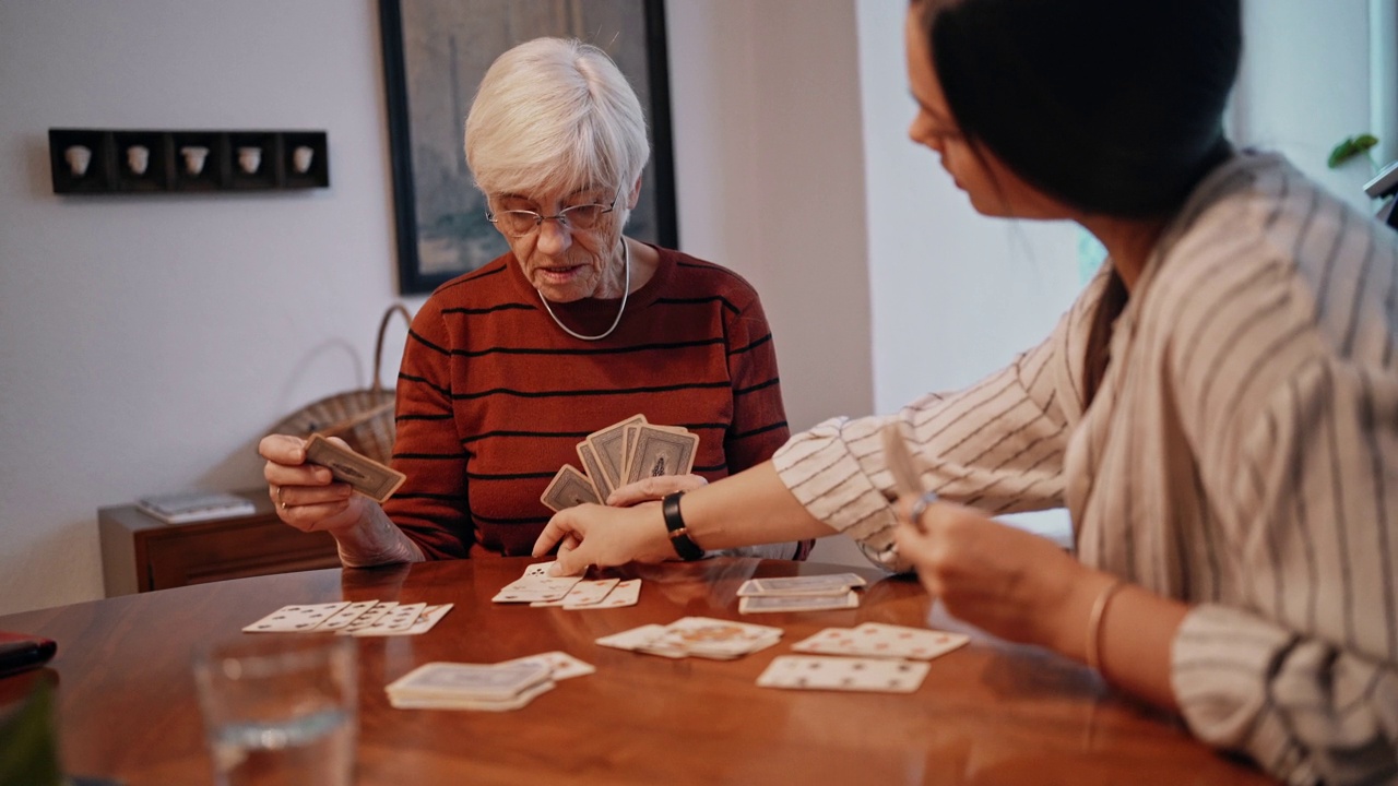老太太和女护士在餐厅打牌视频素材