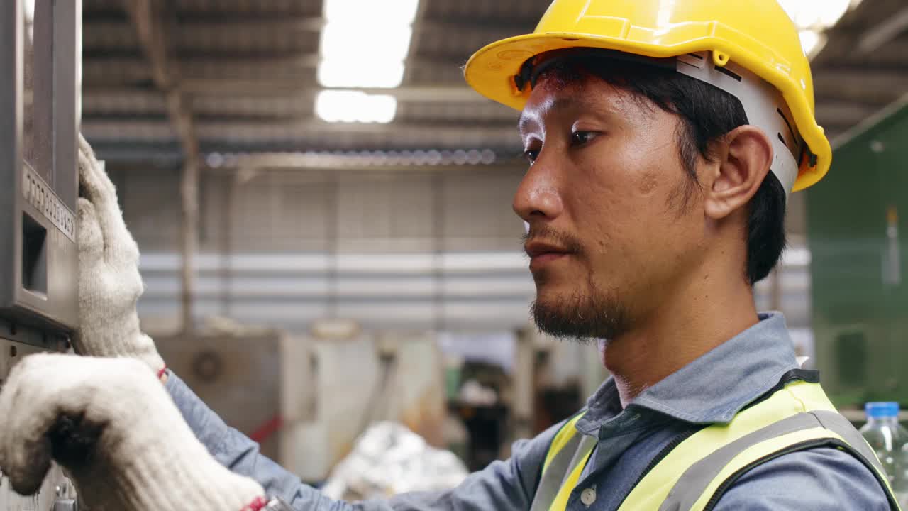 男性工业工人按下工业机器控制面板上的按钮。视频素材