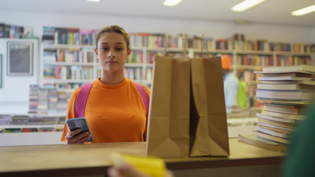 十几岁的女孩在旧货店用手机付款视频下载