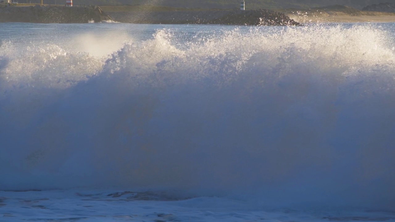 海浪拍打海岸的慢动作无人机视频。大西洋力量在运转。海浪淹没了海滩。风暴海洋能量的俯视图。海岸线周围有强大的海浪。视频素材