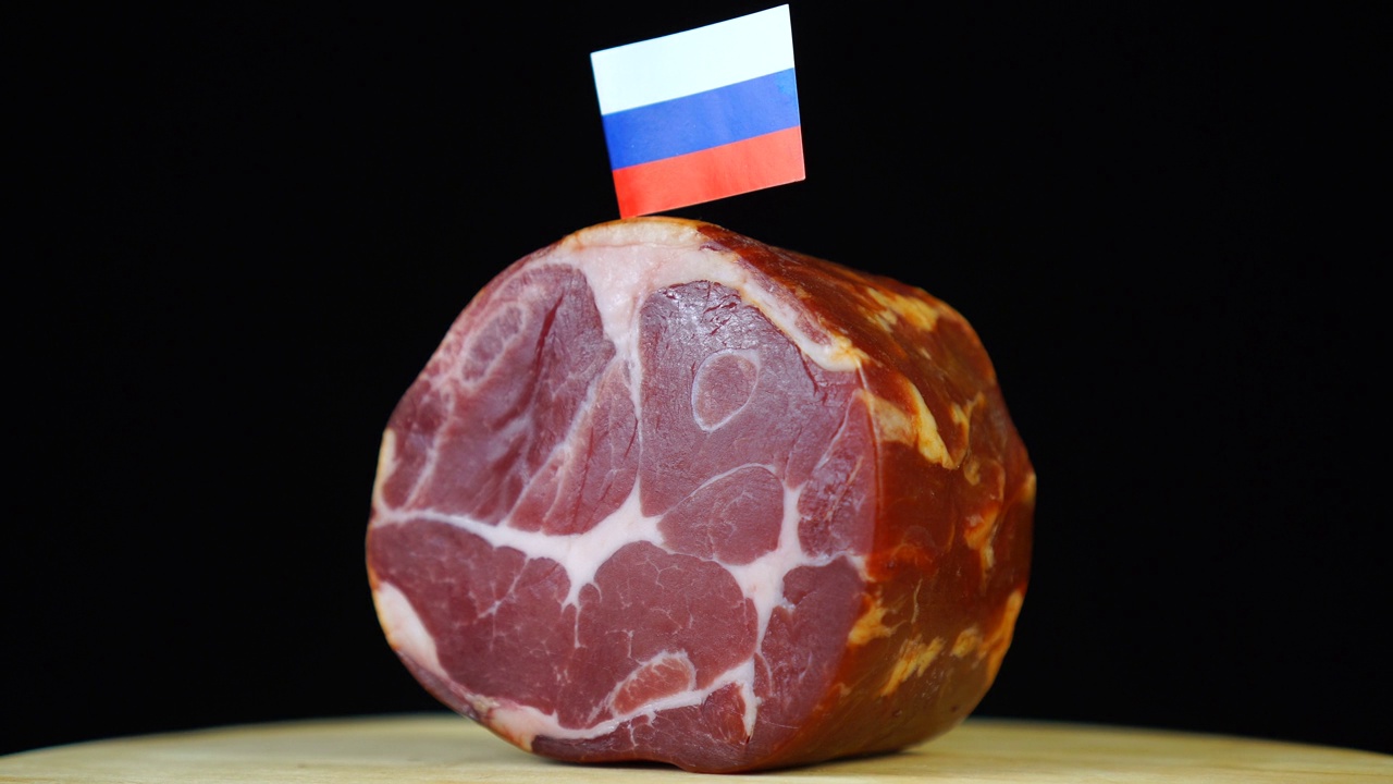 美味的烟熏里脊肉配俄罗斯小旗，黑色背景上的一块肉旋转着。视频素材