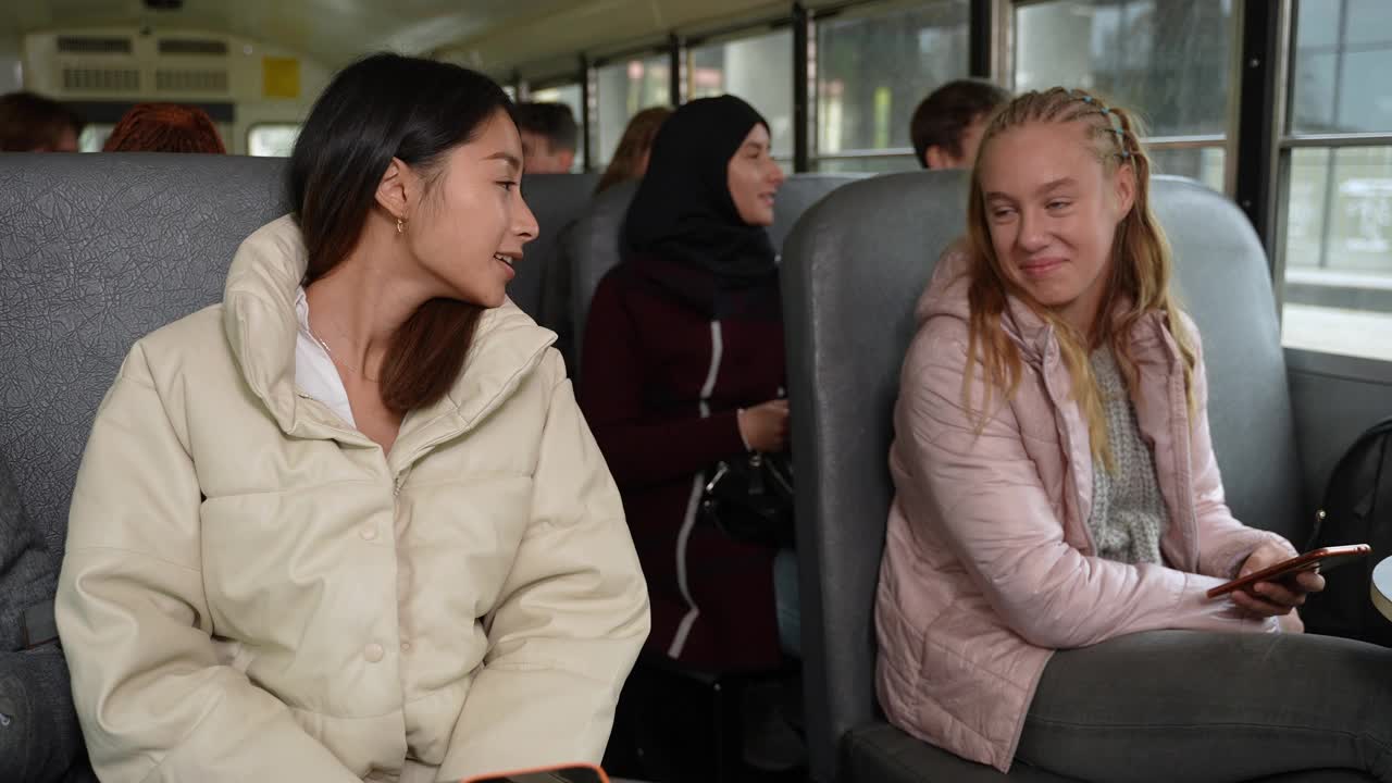 快乐的多种族女孩在校车上交谈视频下载