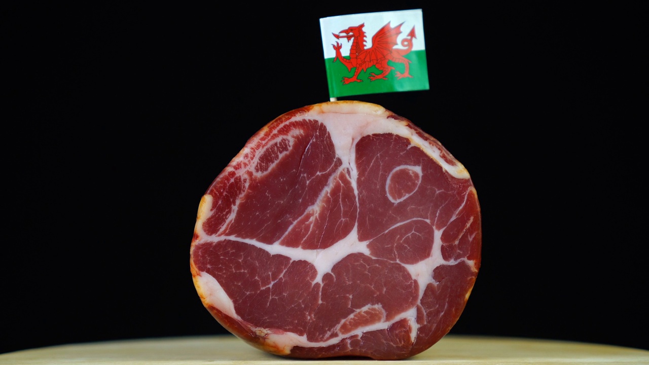 美味的烟熏里脊配威尔士小旗，黑色背景上的一块肉旋转着。视频素材