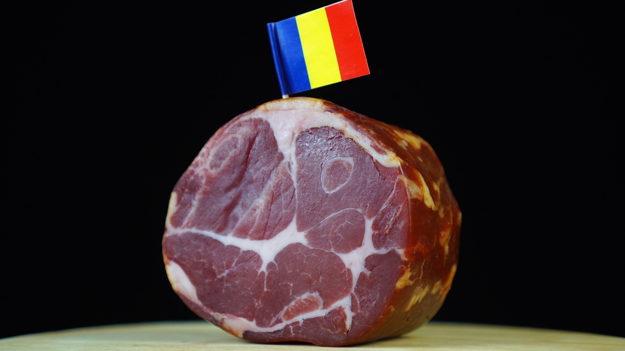 美味的烟熏里脊肉配罗马尼亚小旗，黑色背景上的一块肉旋转着。视频素材