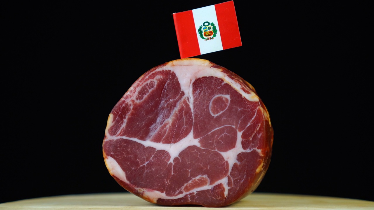 美味的烟熏里脊肉配秘鲁小旗，黑色背景上的一块肉旋转着。视频下载