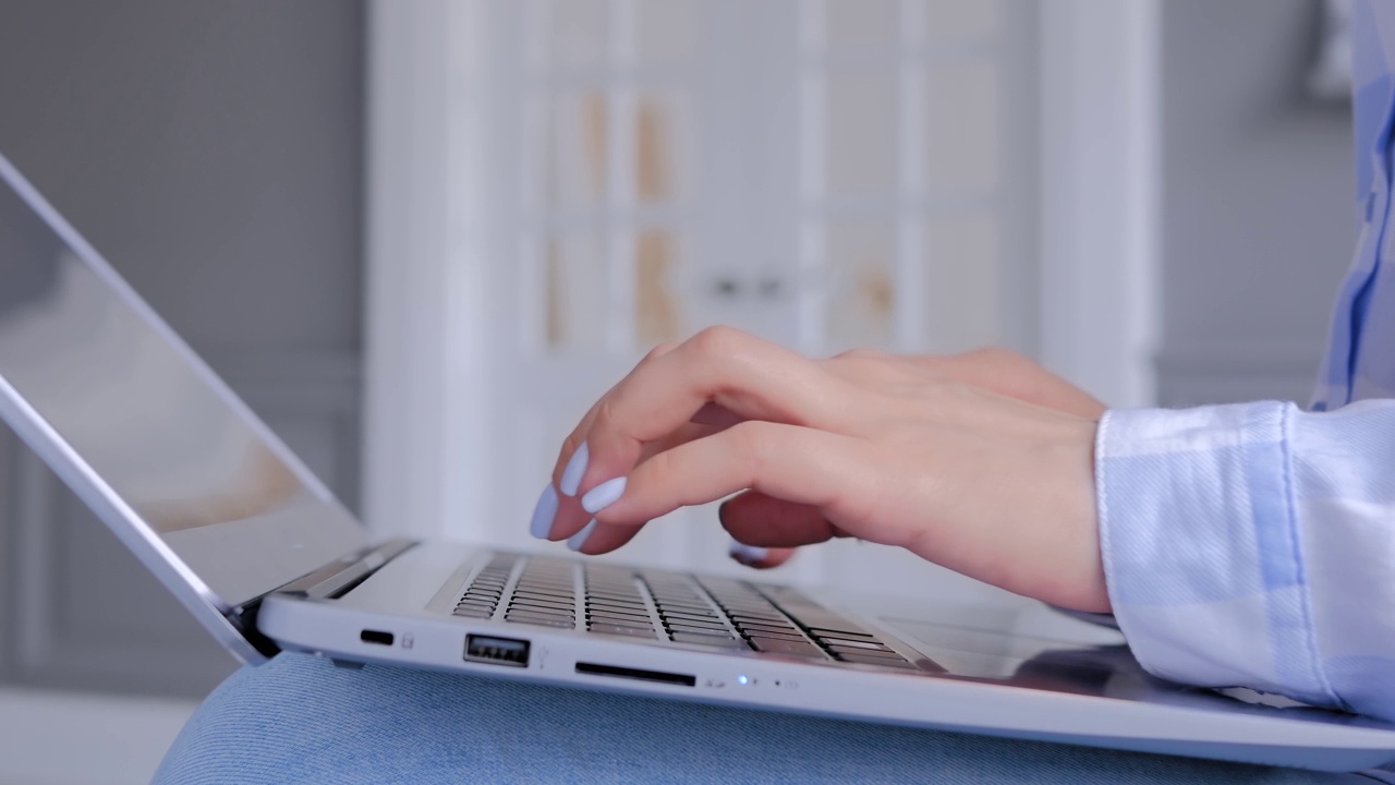 近看侧面-女人的手打字在笔记本电脑键盘视频素材