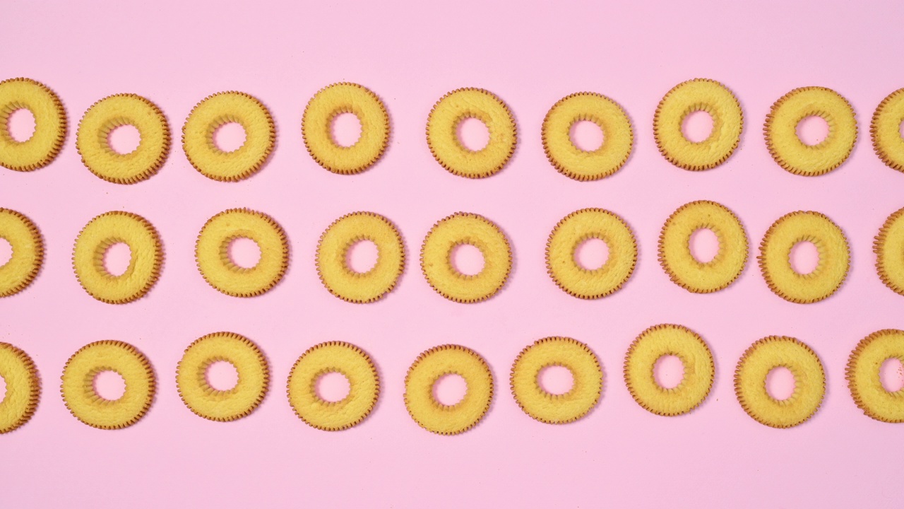 三列圆形饼干出现，并在淡粉色主题上移动。停止运动视频下载