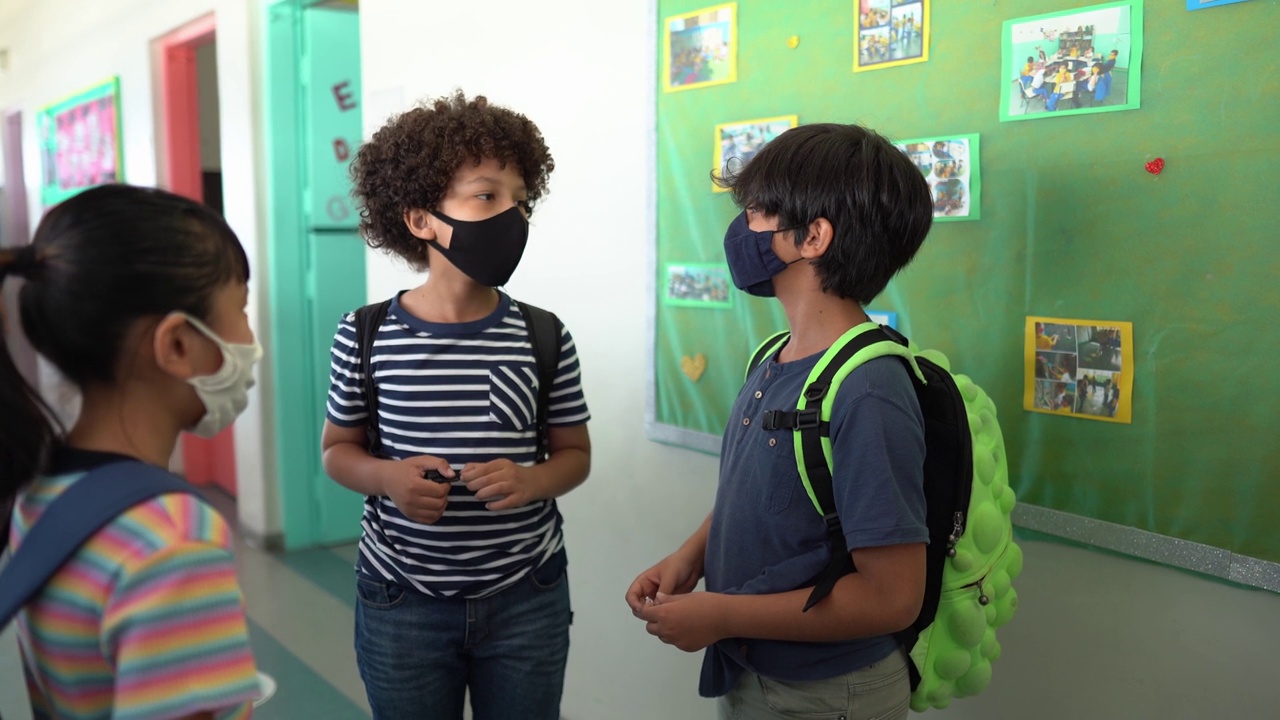 学生在学校走廊里说话，戴着防护口罩视频下载
