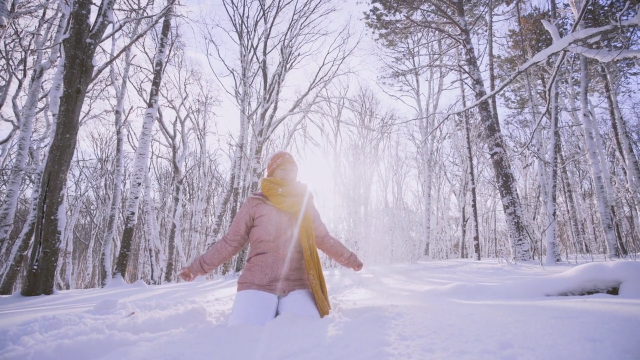 快乐的女人在冬天的森林里玩耍视频素材
