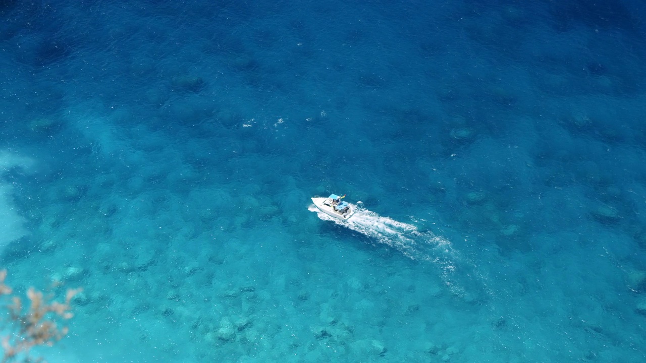 岛上的旅游游船在蓝色的海水中跳跃。俯视图视频素材
