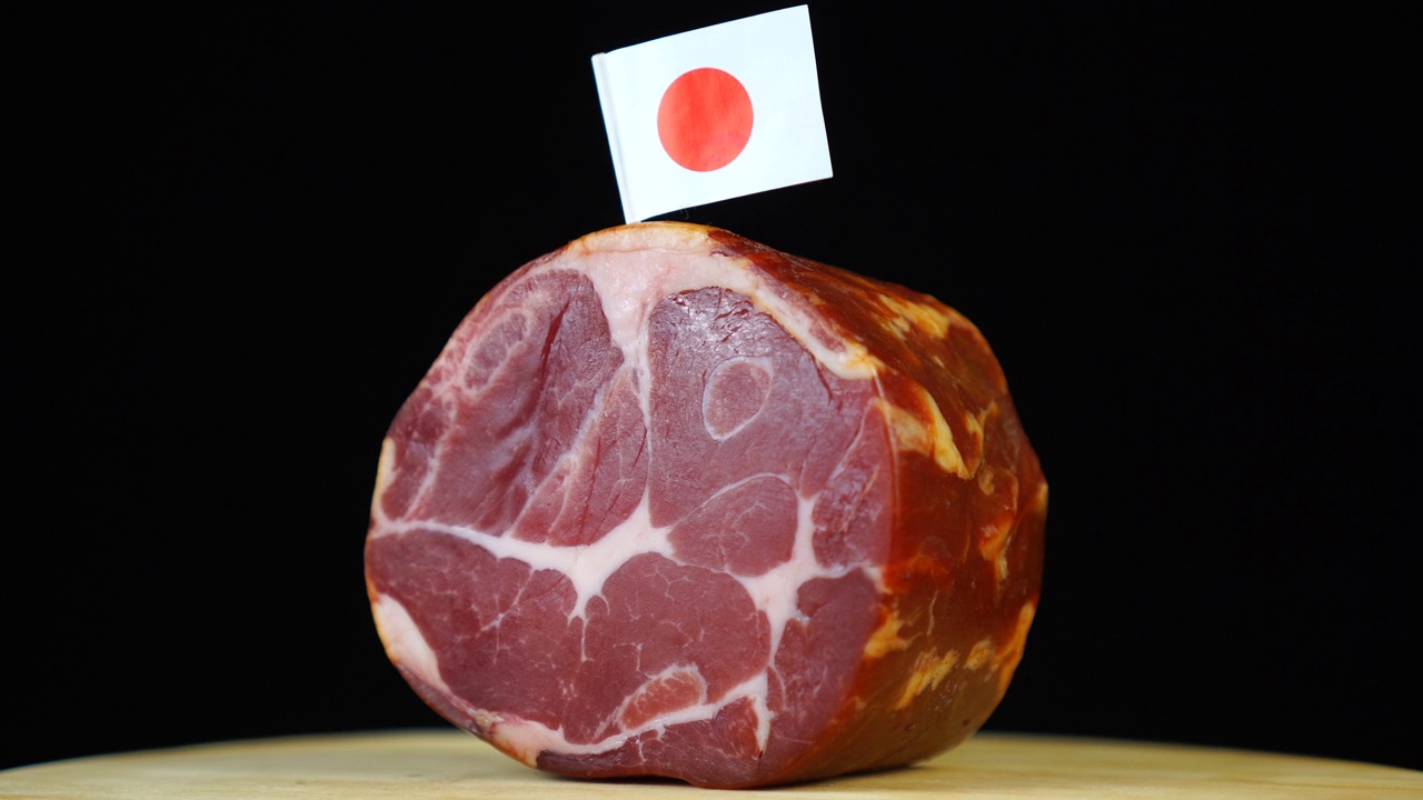 美味的烟熏里脊配日本小旗，黑色背景上的一块肉旋转着。视频素材