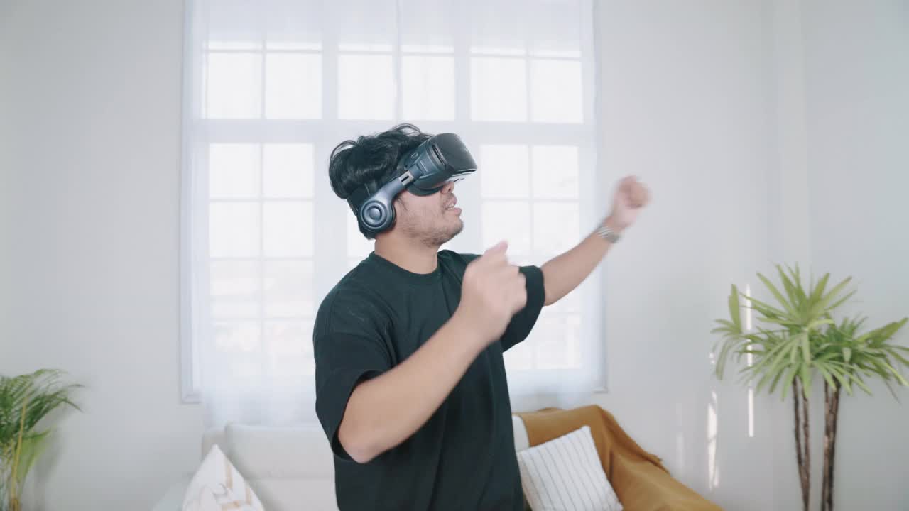 快乐的男人在家里用虚拟现实耳机跳舞视频下载